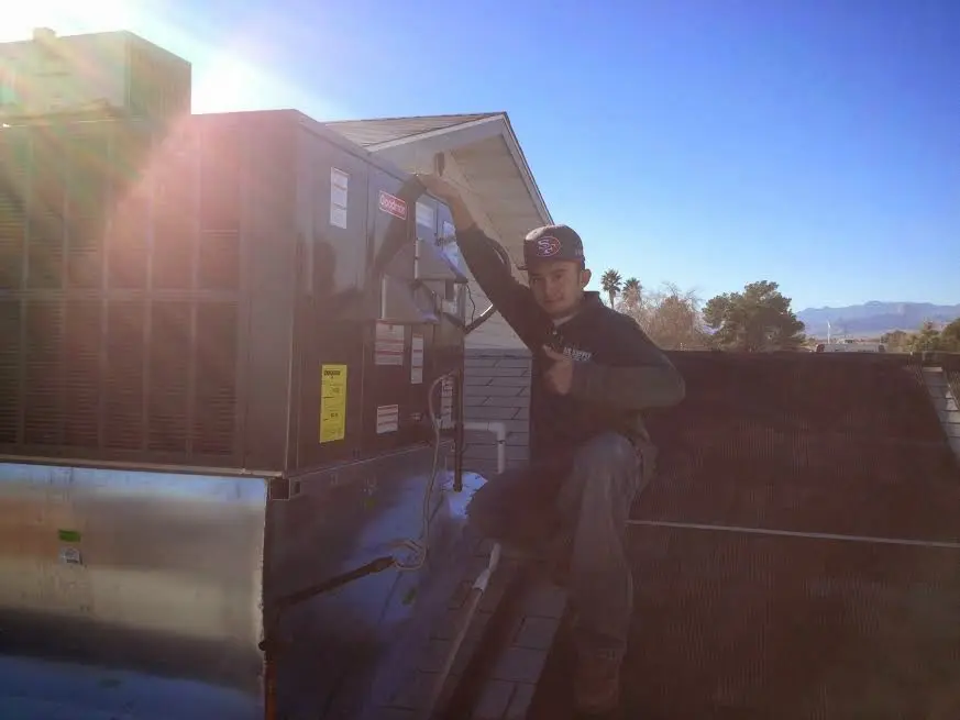 HVAC technician performing Air Duct Cleaning on a rooftop unit in Mayfield